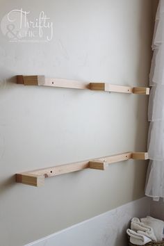 two wooden shelves on the wall in a bathroom