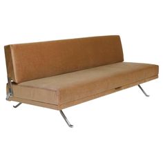 a brown couch sitting on top of a metal frame with an arm rest and footrests