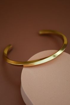 Ultimately simplistic with a unique curved design. This adjustable bangle bracelet is modern and shiny with a gorgeous twisted pattern. Gold dipped and made from a stainless steel metal. Modern Twist Polished Bangle Cuff Bracelet, Adjustable Metal Bangle In Minimalist Style, Adjustable Stainless Steel Bangle With Polished Finish, Adjustable Minimalist Metal Bangle, Minimalist Adjustable Bangle With Polished Finish, Adjustable Minimalist Bangle With Polished Finish, Modern Adjustable Bangle With Polished Finish, Adjustable Bangle With A Modern Twist, Modern Twist Adjustable Bangle As A Gift