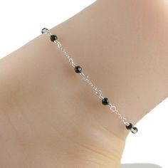 This elegant anklet features black Swarovski crystals and lovely sterling silver chain and fastens with a sterling silver lobster clasp. An ideal companion to that little black dress! Please choose the size that you need from the drop down menu, bearing in mind that the anklet should be approximately one inch larger than the size of your ankle. The anklet will arrive in an attractive gift box. *Anklet available with gold chain Black Silver Chain Bracelet As Gift, Black Silver Chain Bracelet Gift, Elegant Black Bracelets With Silver Chain, Black Silver Chain Bracelet For Gift, Elegant Black Bracelet With Silver Chain, Black Anklet For Women, Silver Anklet With Black Beads, Elegant Black Beaded Anklets, Black Silver Anklets