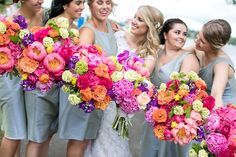 a group of women standing next to each other holding bouquets