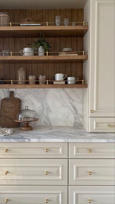 a kitchen with marble counter tops and wooden shelves