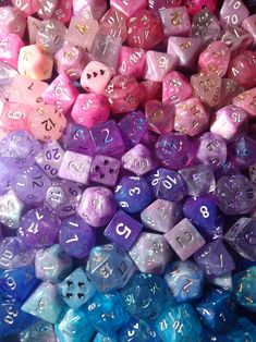 many different colored dices are stacked on top of each other, with numbers written on them