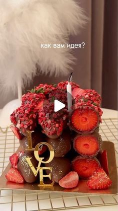 a chocolate cake with strawberries on top and the words love spelled in russian above it