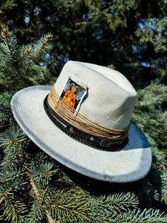 This custom cowboy hat is titled "The Devil" and features personalized distressing and accessories that can be found on the hat. The hat contains burned twine, black metal chains, a leather band, and a burned devil tarot card attached to the side. The cowboy hat is a one-size-fits-most. Please do keep that in mind before purchasing, thanks! Don't miss out on the opportunity of owning this one-of-one piece, it will never be recreated again! Distressed Adjustable Fedora For Rodeo, Rustic Distressed Hat For Western-themed Events, Rustic Adjustable Distressed Hat Bands, Vintage Distressed Hat For Western-themed Events, Distressed Adjustable Country Hat Band, Distressed Bohemian Hat Band For Festivals, Handmade Rustic Hat Band For Festivals, Distressed Bohemian Hat Bands For Festivals, Rustic Handmade Hat Bands For Festivals