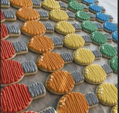 cookies decorated in different colors and shapes on a baking sheet