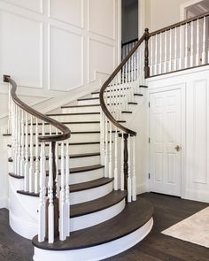 there is a white and brown staircase in the house