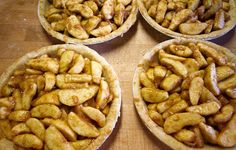 four pies filled with bananas sitting on top of a wooden table