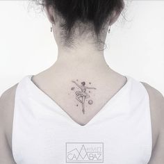 a woman with a small tattoo on her neck and behind her is a white tank top