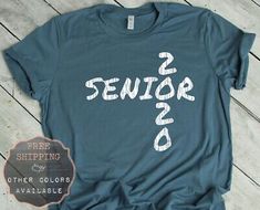 a t - shirt with the words senior 2 and other colors available for sale on a wooden floor