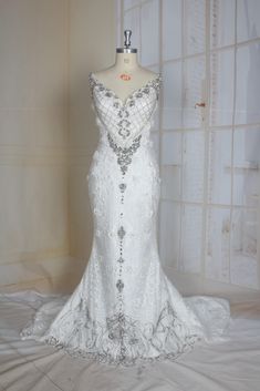 a white wedding dress on display in front of a wall