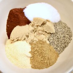 a white bowl filled with different types of spices