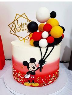 a mickey mouse cake with balloons on top