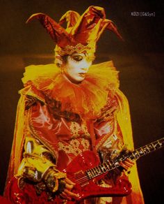 a man in costume holding a red guitar