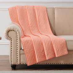 a couch with a pink blanket on top of it