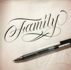 a pen sitting on top of a piece of paper with the word family written in cursive writing