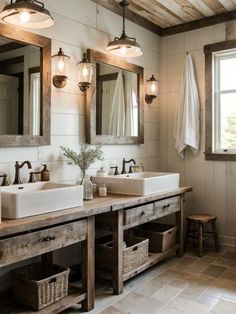 a bathroom with two sinks, mirrors and lights on the wall next to each other