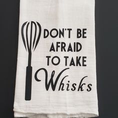 a tea towel with the words don't be afraid to take whisks on it