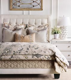 a bed with pillows and blankets on top of it in a bedroom next to a dresser