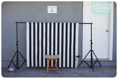 two black and white striped backdrops in front of a door with a stool next to it