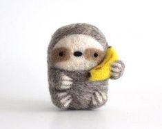 a stuffed slotty holding a banana in it's right hand on a white surface