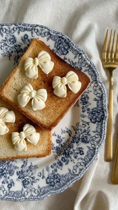 two pieces of bread with white icing on them sitting on a blue and white plate