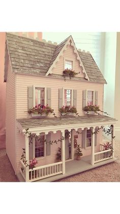 a doll house with flowers on the windows and balconies over the front porch