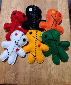 four different colored stuffed animals sitting on top of a wooden table