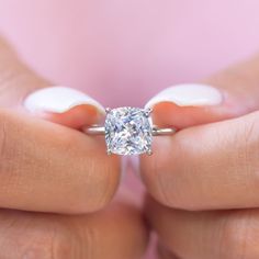 a woman holding a diamond ring in her hands