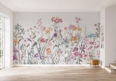 an empty room with flowers painted on the wall and wood flooring in front of it