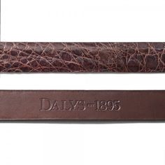 an old leather watch strap with the date dated on it and brown alligator - embossed leather