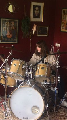 a woman sitting in front of a drum set