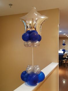 blue and white balloons are hanging on the wall