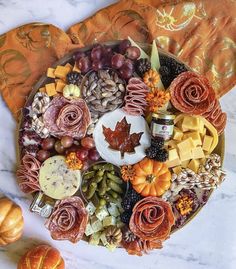 a platter filled with different types of cheeses, nuts and other food items