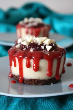 two desserts with red and white icing are on a blue plate, ready to be eaten