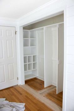 an empty room with white closets and wood floors