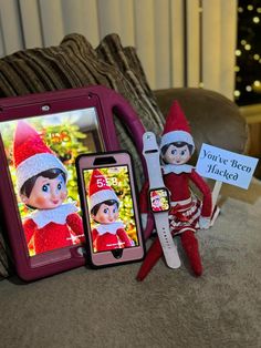 an elf is sitting next to two cell phones