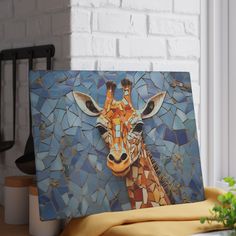 a giraffe's head is depicted on a mosaic tile wall in front of a potted plant