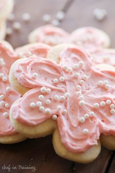 some cookies with pink icing are on a table