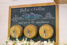 three wooden barrels are on display in front of a chalkboard with the name kate and collin