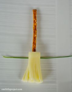 a yellow broom sitting on top of a piece of paper next to a green cord