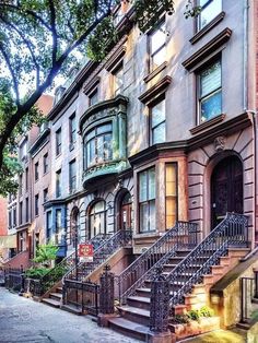 a row of brownstone townhouses with wrought iron railings