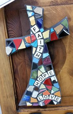 a cross made out of stained glass with the word faith spelled in letters on it