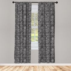 a window with black and white curtains on it in front of a wooden flooring area