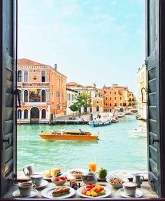 the view from an open window shows boats and buildings