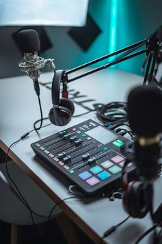 a recording studio with headphones, microphone and sound board on a table in front of a large screen