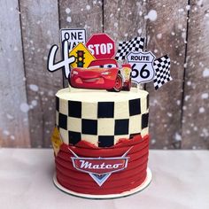 a birthday cake with cars on top and street signs in the backgroung