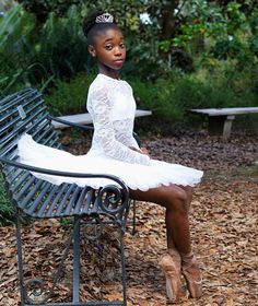 a woman in a white dress sitting on a bench