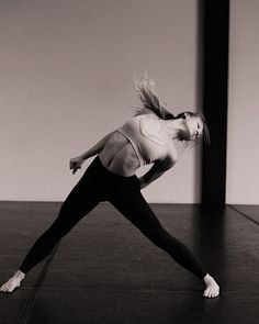 a woman in black and white is doing yoga