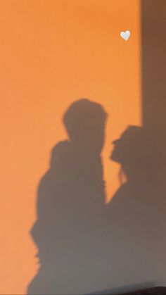 the shadow of two people standing next to each other